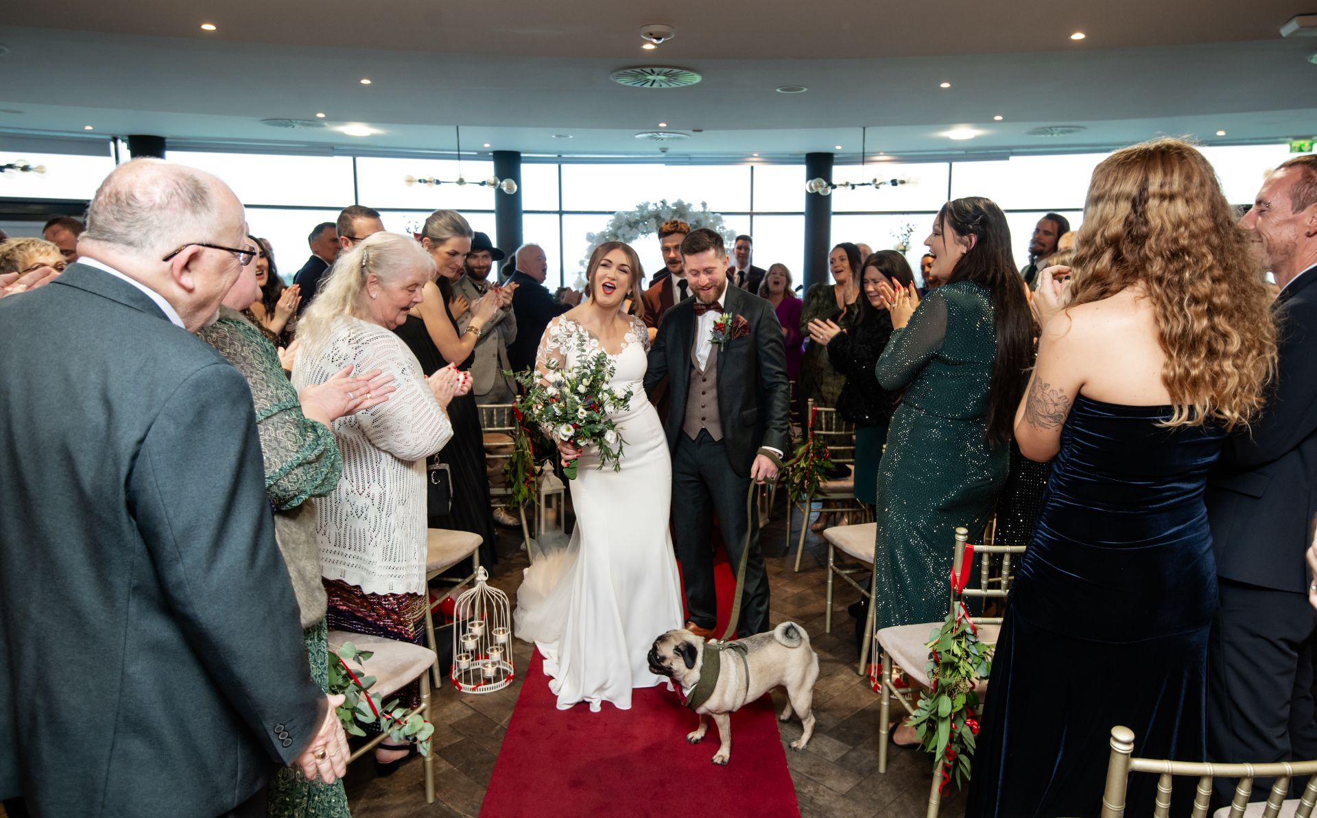 Bride and groom walking down the aisle with their pug at an Irish wedding ceremony